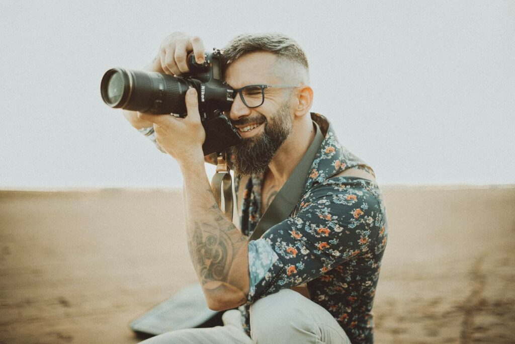Un photographe tient un appareil photo avec un télé objectif